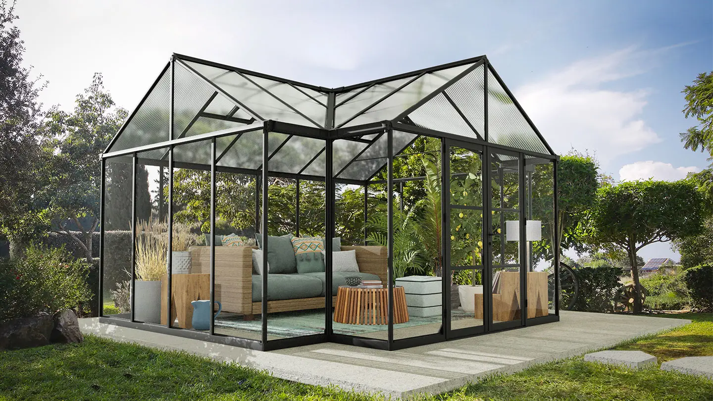 Schwarzes Aluminium-Gewächshaus in T-Form in einem Garten mit Möbeln im Inneren