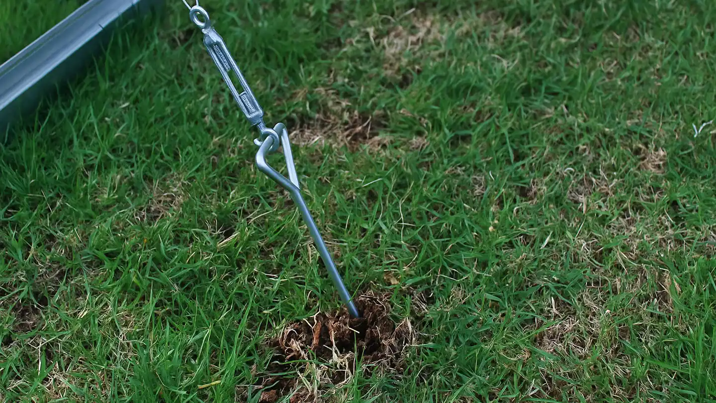 Gewächshaus-Befestigungsset im Gras verankert